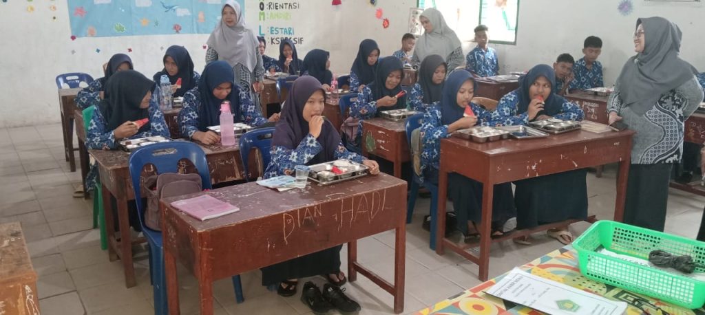Foto : Siswa MTsN Simalungun saat menikmati makan gizi gratis. (Suarajurnalis.id/Budi Kurnia)